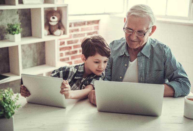 Old man on laptop with child