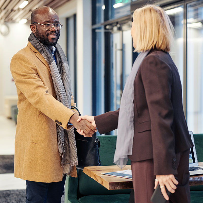 African man shaking hands with female executive